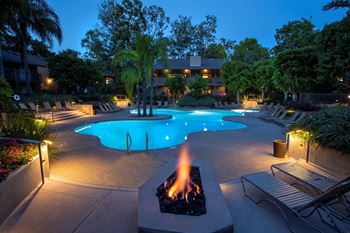 A pool with a fire pit in the middle of it.